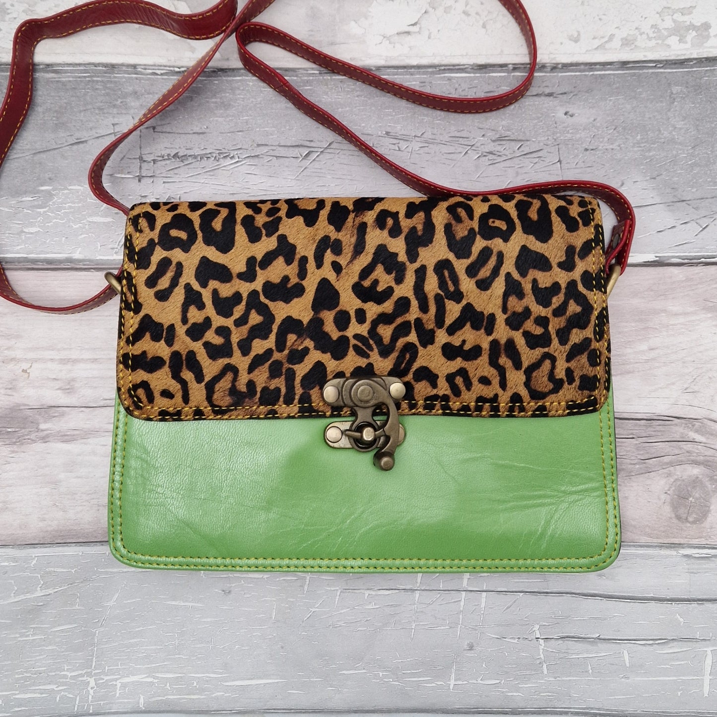 All leather bright green coloured bag with a textured panel of jaguar animal print. A brass swivel clasp secured the bag at the front.