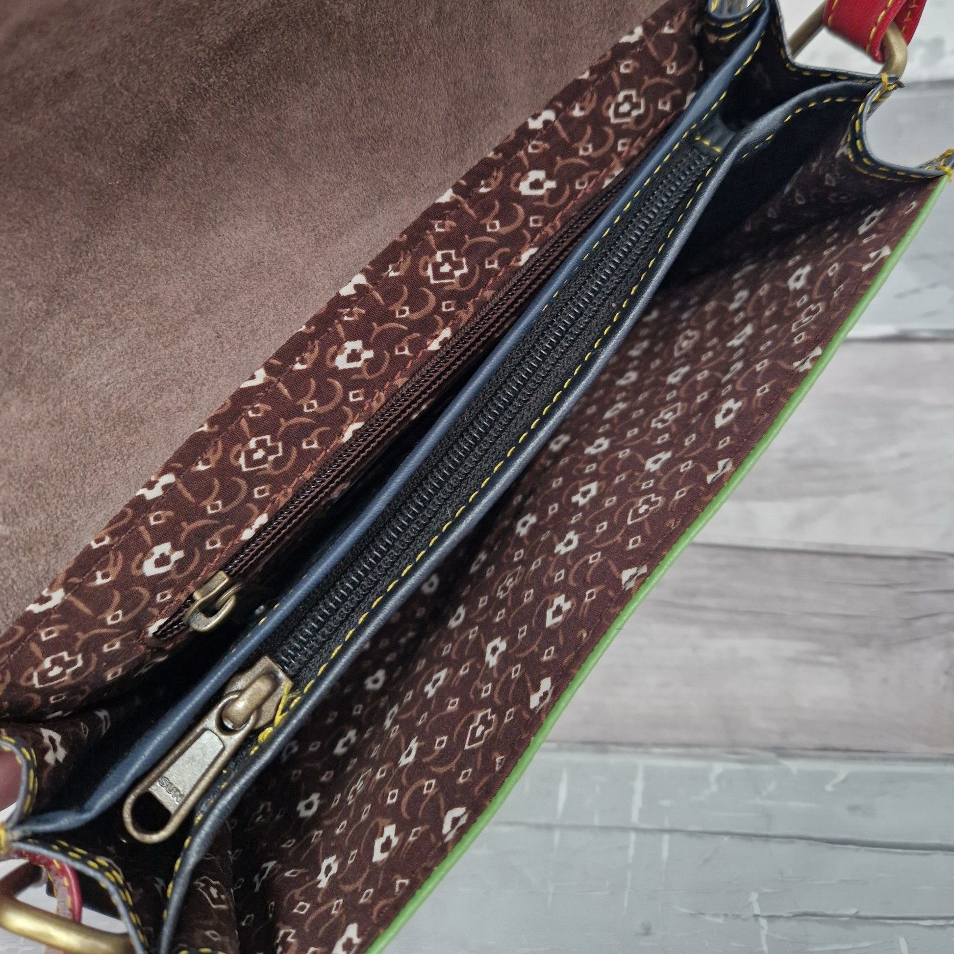 Inside view of Tiya style bag showing 3 sections including 2 internal zipped pockets.