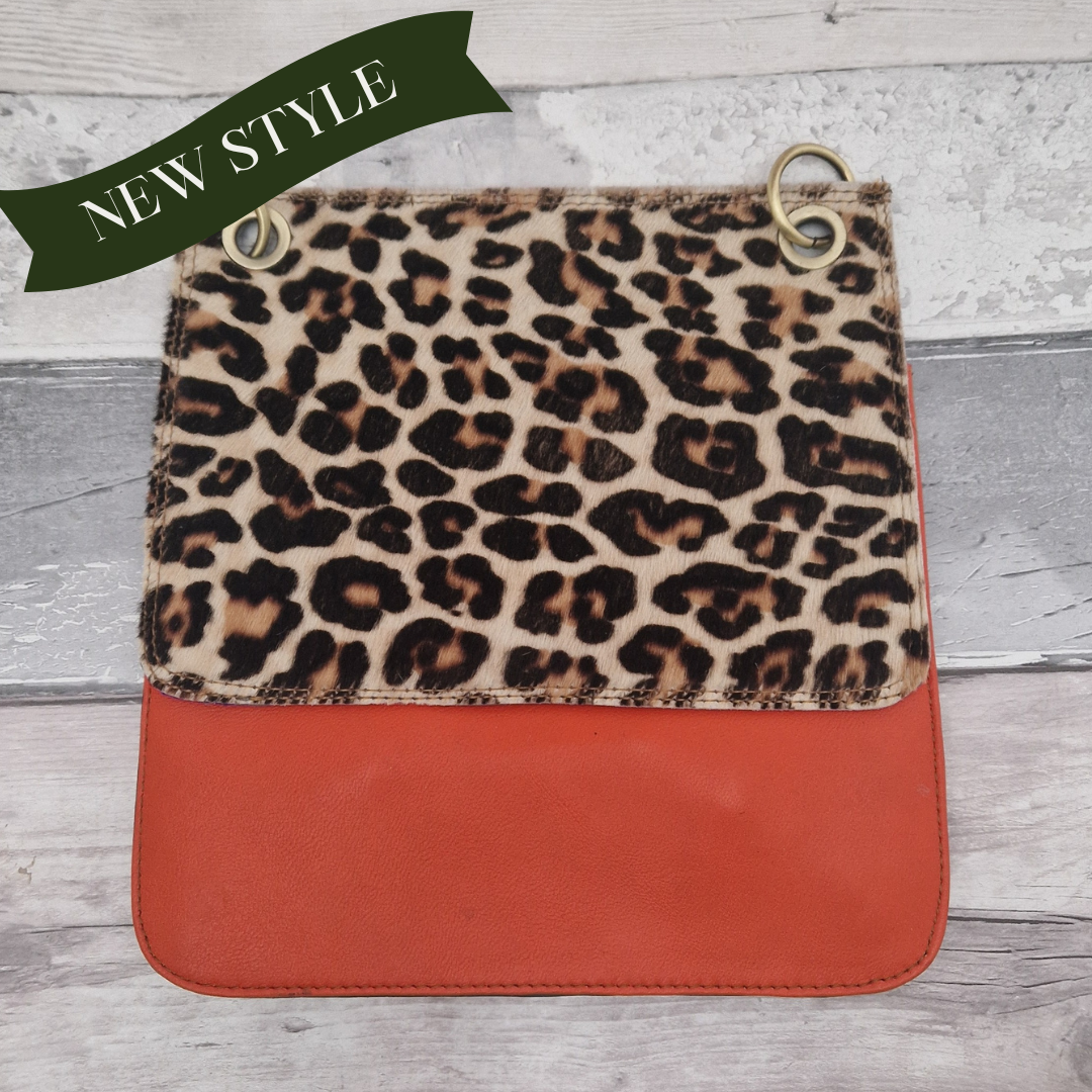 All leather modern messenger style bag with a bright orange panel and textured leopard print panel.