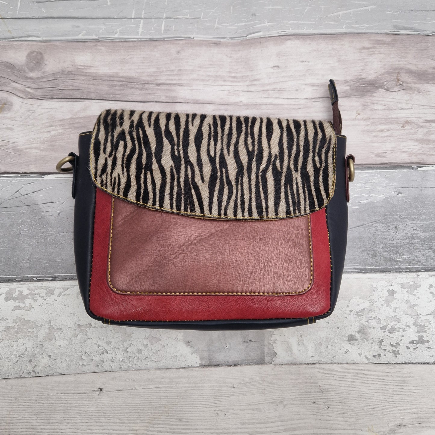 All leather messenger style bag in Metallic Pink, Red and Dark inky tones with a textured panel of Zebra print.