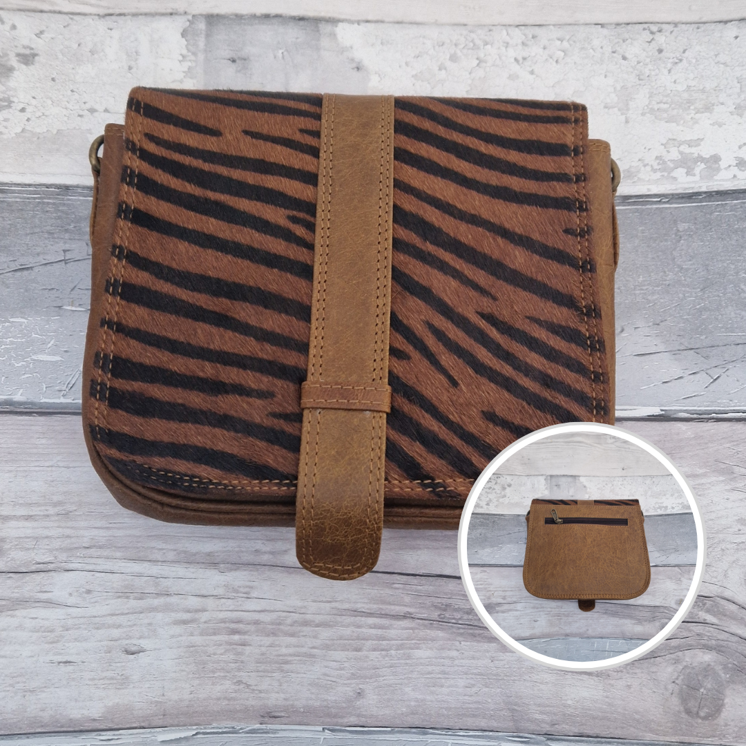 Zoya is a Messenger style bag with a tab on the front to lift for access. She is made from leather off-cuts and is presented in a multitude of colours finished with a large front panel in textured tiger animal print.